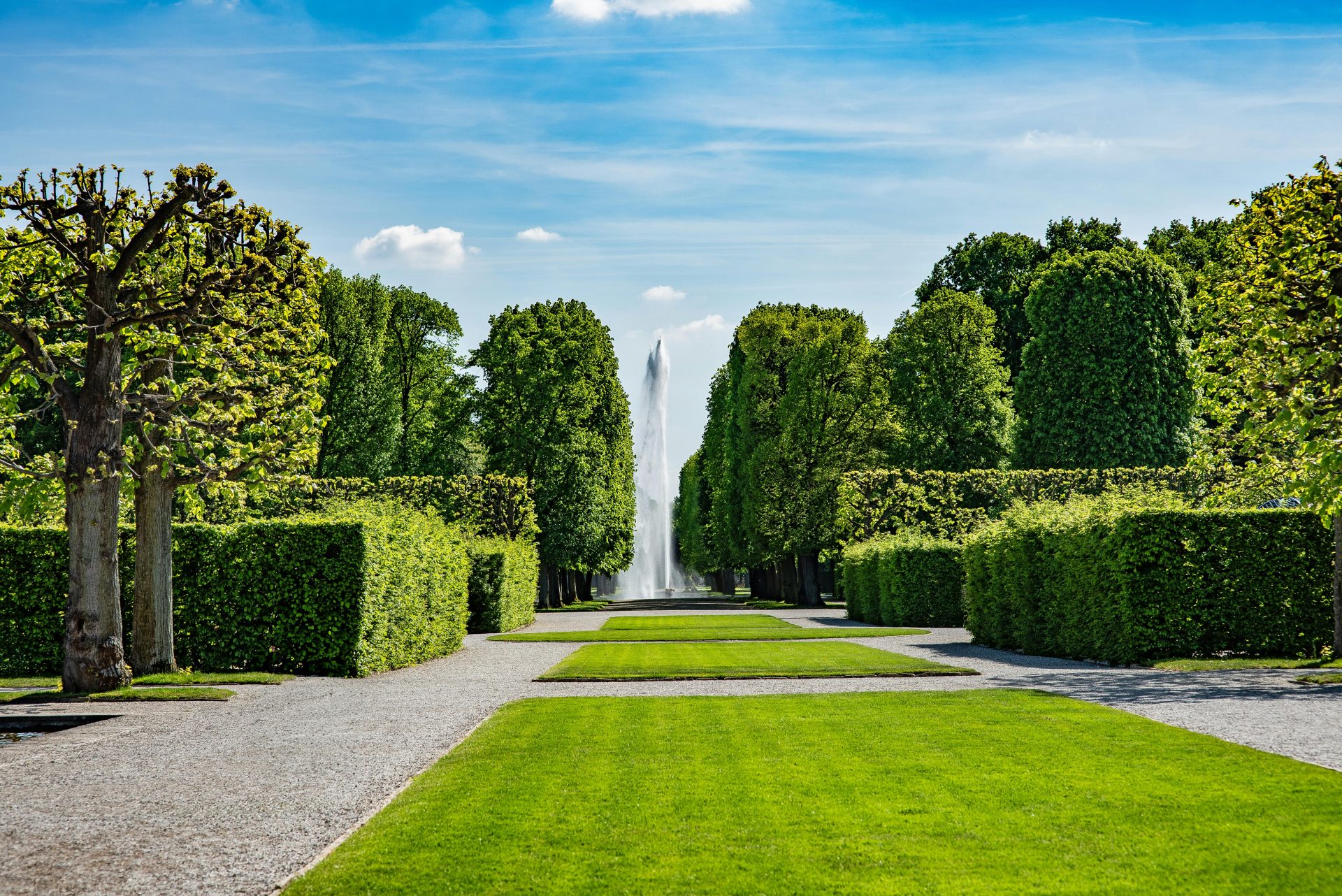 Ein üppig grüner Park mit einem Springbrunnen in Hannover – perfekt für eine ruhige Auszeit.